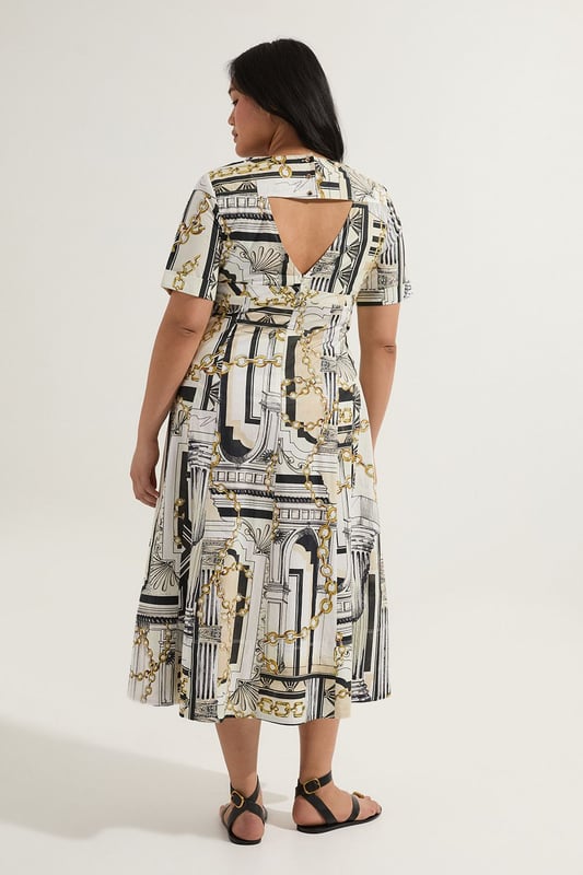 Striking Roma print featuring architectural motifs and chain details Flattering V-neckline and short sleeves Full skirt design for a dramatic silhouette Midi length perfect for various occasions Crafted from soft cotton sateen for comfort and style  Make a statement in this eye-catching Karen Millen plus size midi dress. The Roma print, adorned with architectural elements and chain motifs, creates a captivating visual impact. The V-neckline and short sleeves offer a flattering frame, while the full skirt adds a touch of drama to your ensemble. Perfect for daytime events, this dress can be styled with flat sandals and a tote bag for a casual lunch date or family gathering. Layer with a denim jacket for a more relaxed look, or add a belt to accentuate your waist. The versatile midi length allows for easy transition from day to evening, making it a go-to piece for various occasions. Embrace the artistic print and let this dress become the focal point of your outfit, pairing it with minimal accessories to let the design truly shine.