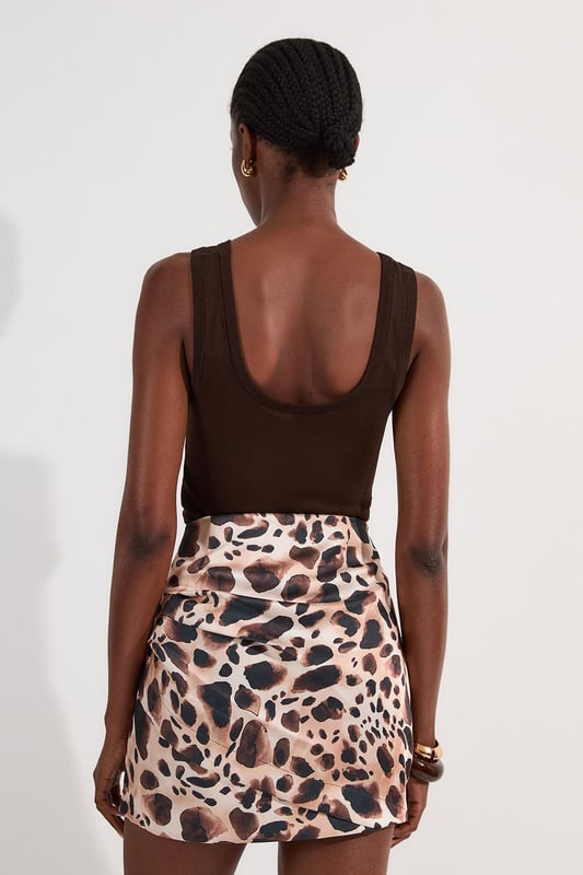 Make a statement at your next soiree with this captivating animal print mini skirt, featuring ruched detail for a figure-flattering silhouette. Pair it with a sleek bodysuit or a crisp white blouse for a sophisticated ensemble perfect for cocktail parties or upscale dinners. For a more daring look, team it with a matching animal print top and strappy heels. The versatile design allows for both dressed-up and casual styling options; wear it with a leather jacket and ankle boots for a chic day-to-night transition. This skirt is an ideal choice for those seeking to inject a touch of wild glamour into their wardrobe, suitable for a range of occasions from formal events to nights out on the town.  Striking animal print pattern for a bold, eye-catching look Ruched detailing adds texture and flattering dimension Structured viscose satin fabric offers a luxurious feel and drape Mini length design for a flirty, leg-lengthening effect High-waisted silhouette accentuates the waistline