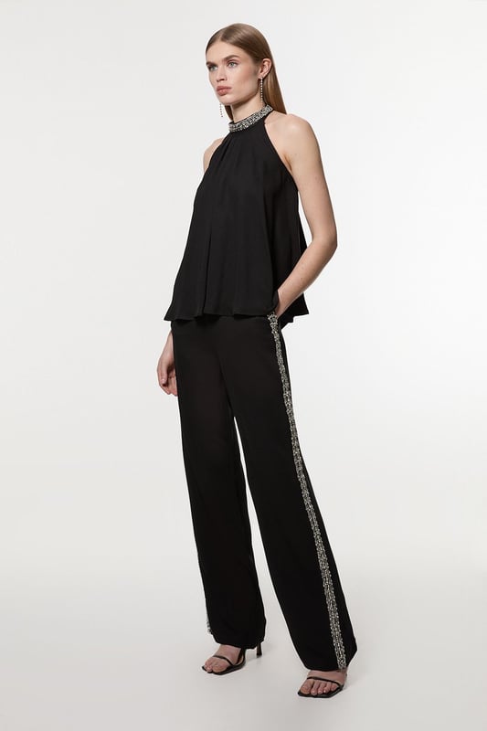 Experience sleek tailoring in a pair of straight leg trousers, with a flattering, relaxed fit and a comfortable high waistline. The sparkling embellishments are hand placed and make for a striking occasion look. Style it with the matching top for a co-ordinating look, or with a blazer and boots for a more laid back approach. Hand Embellished Cady Woven Trouser High Quality Tailored Design Comfortable High Waistline Flattering Straight Leg Fit Sparkling Hand Embellished Strip Down Sides Pocket Accents Matching Top Sold SeparatelyDiscover our collection of occasion wear or browse our range of women's occasion dresses now.