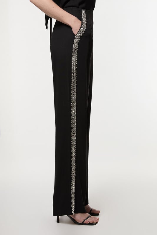 Experience sleek tailoring in a pair of straight leg trousers, with a flattering, relaxed fit and a comfortable high waistline. The sparkling embellishments are hand placed and make for a striking occasion look. Style it with the matching top for a co-ordinating look, or with a blazer and boots for a more laid back approach. Hand Embellished Cady Woven Trouser High Quality Tailored Design Comfortable High Waistline Flattering Straight Leg Fit Sparkling Hand Embellished Strip Down Sides Pocket Accents Matching Top Sold SeparatelyDiscover our collection of occasion wear or browse our range of women's occasion dresses now.