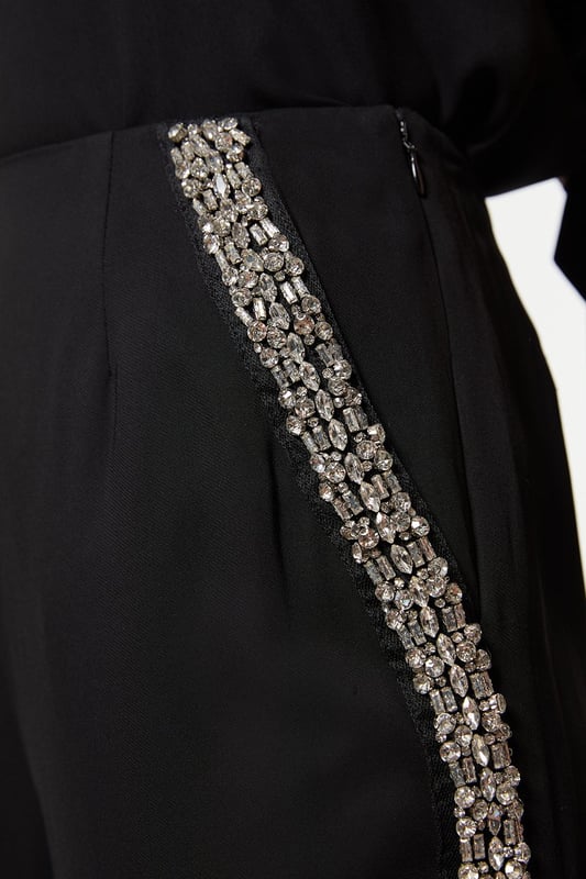 Experience sleek tailoring in a pair of straight leg trousers, with a flattering, relaxed fit and a comfortable high waistline. The sparkling embellishments are hand placed and make for a striking occasion look. Style it with the matching top for a co-ordinating look, or with a blazer and boots for a more laid back approach. Hand Embellished Cady Woven Trouser High Quality Tailored Design Comfortable High Waistline Flattering Straight Leg Fit Sparkling Hand Embellished Strip Down Sides Pocket Accents Matching Top Sold SeparatelyDiscover our collection of occasion wear or browse our range of women's occasion dresses now.