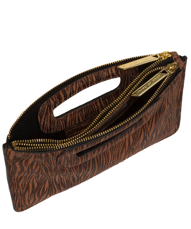 The 'Esher' clutch bag from Pure Luxuries London is handcrafted from luxurious natural leather with a beautifully suede finish. The dual zips, above the built-in handles, secure the dual compartments that come lined with natural, untreated 100% cotton. Additional storage space is provided by a central slip pocket between the zipped compartments, ideal for on-the-go storage. Adorned with the iconic Pure Luxuries London gold foil embossed logo as the perfect finishing touch.