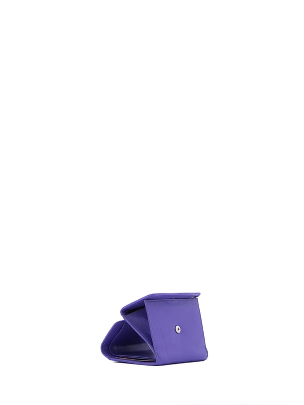 Cartera de mujer. El cierre es con botón de presión. Los bolsillos internos son tarjeteros para billetes y monedas. Los bolsillos externos están ausentes. Falta la correa para el hombro. Falta el mango. Hay dos compartimentos internos. El material exterior es ecopiel. Internamente está forrado en poliéster. Medidas: 9x8x2 cm. Producto de moda