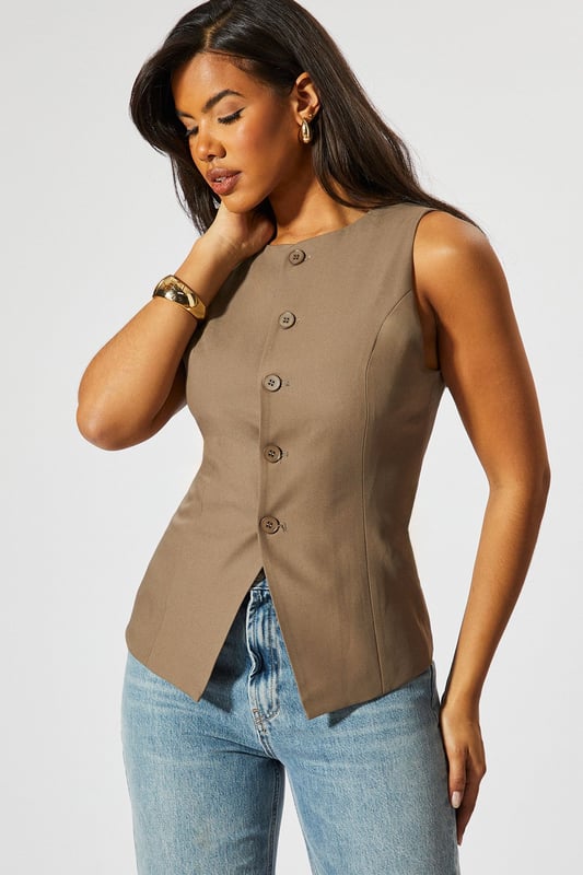 Tailored High Neck Waistcoat Sleek high neck design for a sophisticated look
Tailored fit accentuates the waistline
Unique button-front closure adds visual interest
Versatile sleeveless style perfect for layering
Asymmetrical hem creates a modern silhouette
Make a bold statement with this tailored high neck waistcoat from MissPap. This eye-catching piece combines classic tailoring with contemporary flair, perfect for the fashion-forward woman who loves to stand out. The sleek high neck and button-front closure create a polished look, while the asymmetrical hem adds a touch of edginess. Style it with wide-leg trousers and strappy heels for a chic evening ensemble, or layer it over a crisp white shirt and pair with jeans for a smart-casual daytime look. The versatile design makes it ideal for various occasions, from casual gatherings to nights out on the town. This waistcoat is a must-have addition to any wardrobe, offering endless styling possibilities and ensuring you'll always be the centre of attention.