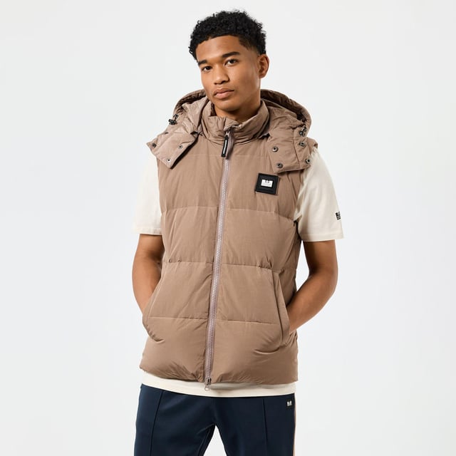 Mens Weekend Offender Gordini Down Gilet in brown.- Removable four-piece quilted hood.- Internal drawstring at the hem and hood.- Sleeveless.- Two-way chunky centre front zip with WO branded zip puller.- Large angled welt pockets with hidden snap studs  polar fleece lining and shiny herringbone tape.- Invisible zip on the back neck with hidden balaclava attached.- New Scan me QR code label inside.- Detachable WO badge on the chest.- Shell: 100% Nylon with Polyurethane Backing. Fulling: 70% Down  30% Feather.- Ref: JKAW2417BRO