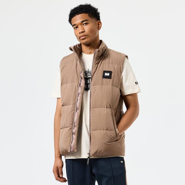 Mens Weekend Offender Gordini Down Gilet in brown.- Removable four-piece quilted hood.- Internal drawstring at the hem and hood.- Sleeveless.- Two-way chunky centre front zip with WO branded zip puller.- Large angled welt pockets with hidden snap studs  polar fleece lining and shiny herringbone tape.- Invisible zip on the back neck with hidden balaclava attached.- New Scan me QR code label inside.- Detachable WO badge on the chest.- Shell: 100% Nylon with Polyurethane Backing. Fulling: 70% Down  30% Feather.- Ref: JKAW2417BRO