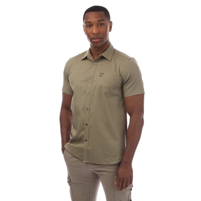 Mens Lyle And Scott Short Sleeve Poplin Shirt in olive.- Classic collar.- Short sleeves.- Full button fastening.- Chest pocket.- Lyle And Scott Golden Eagle logo patch embroidered on the pocket.- Curved hem.- 97% Cotton  3% Elastane.- Ref: SW1807VW908