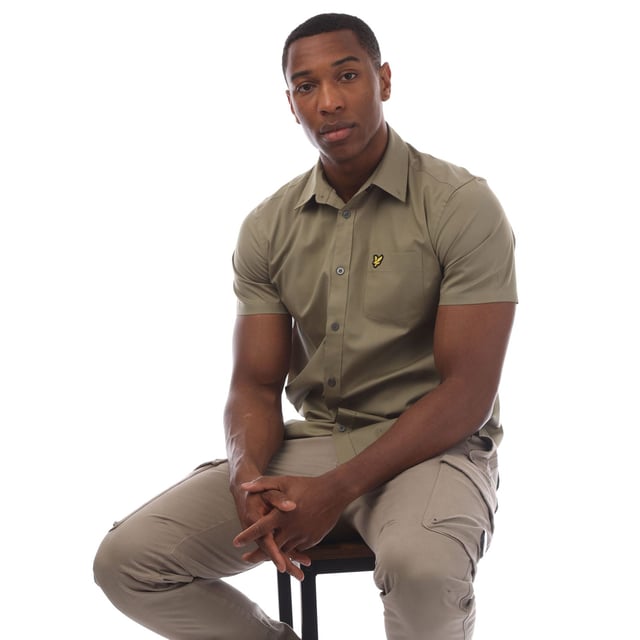 Mens Lyle And Scott Short Sleeve Poplin Shirt in olive.- Classic collar.- Short sleeves.- Full button fastening.- Chest pocket.- Lyle And Scott Golden Eagle logo patch embroidered on the pocket.- Curved hem.- 97% Cotton  3% Elastane.- Ref: SW1807VW908