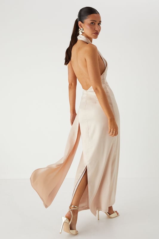 Luxurious satin fabric with a subtle sheen that catches the light beautifully
        Elegant halterneck design with an open back for a striking silhouette
        Sophisticated draped detailing along the side creates flattering movement
        Floor-sweeping maxi length with a daring side split for ease of movement
        Figure-enhancing fit with a smooth lining for comfort and confidence
    
    Command attention at your next special occasion in this show-stopping satin maxi dress from MissPap. The halterneck design frames your dcolletage whilst the open back adds a touch of drama to your ensemble. The expertly crafted side draping creates a flattering silhouette that flows with your every move, whilst the daring side split offers both practicality and allure. Style with strappy metallic heels as seen on our model and statement earrings for a head-turning look perfect for weddings, formal events or graduation ceremonies. For cooler evenings, pair with a delicate shawl or a tailored blazer to maintain the dress's elegant lines. This versatile piece transitions effortlessly from daytime celebrations to evening affairs, ensuring you remain the focal point of any occasion.