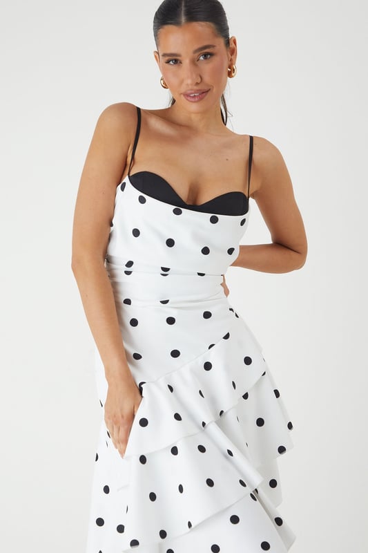 Striking sweetheart neckline with contrasting trim for a bold statement
        Asymmetric layered frill design creates dramatic movement and visual interest
        Elegant maxi length with high-low hemline for a contemporary silhouette
        Adjustable thin straps for a customised and secure fit
        Playful polka dot pattern adds a timeless charm to this occasion piece
    
    Make an unforgettable entrance in this show-stopping polka dot maxi dress from MissPap. The layered frill construction cascades beautifully to create a flattering asymmetric hemline that dances with your every move. The structured sweetheart neckline with its contrasting trim frames your dcolletage perfectly, whilst the fitted bodice cinches the waist for a feminine silhouette. Style with strappy heels and statement earrings as seen on our model for formal events such as weddings or race days. For evening soires, add a sleek clutch and a bold red lip to command attention. This versatile piece transitions effortlessly from daytime garden parties to evening celebrations - simply switch your accessories to reflect the occasion's formality. The lightweight woven fabric ensures comfort without compromising on sophistication.