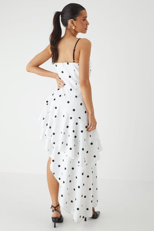Striking sweetheart neckline with contrasting trim for a bold statement
        Asymmetric layered frill design creates dramatic movement and visual interest
        Elegant maxi length with high-low hemline for a contemporary silhouette
        Adjustable thin straps for a customised and secure fit
        Playful polka dot pattern adds a timeless charm to this occasion piece
    
    Make an unforgettable entrance in this show-stopping polka dot maxi dress from MissPap. The layered frill construction cascades beautifully to create a flattering asymmetric hemline that dances with your every move. The structured sweetheart neckline with its contrasting trim frames your dcolletage perfectly, whilst the fitted bodice cinches the waist for a feminine silhouette. Style with strappy heels and statement earrings as seen on our model for formal events such as weddings or race days. For evening soires, add a sleek clutch and a bold red lip to command attention. This versatile piece transitions effortlessly from daytime garden parties to evening celebrations - simply switch your accessories to reflect the occasion's formality. The lightweight woven fabric ensures comfort without compromising on sophistication.