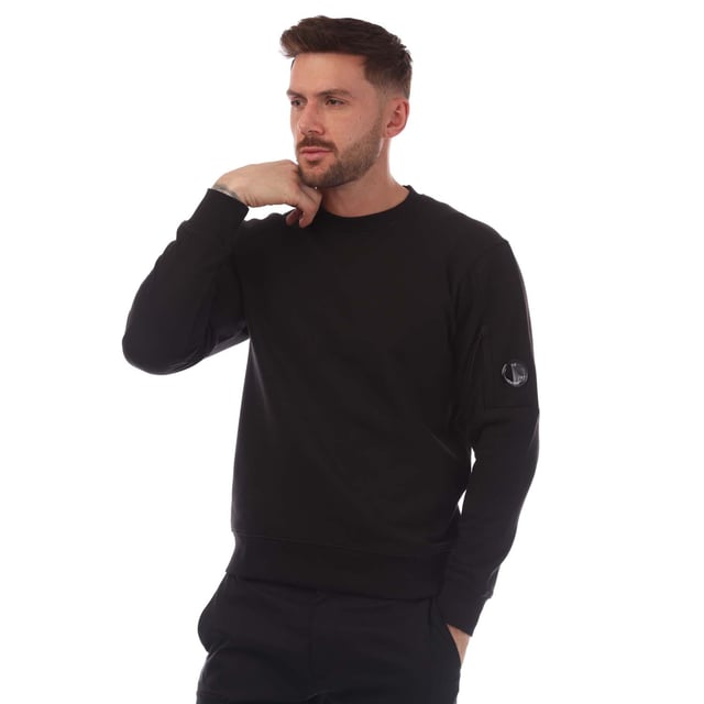 Mens C.P. Company Diagonal Raised Fleece Lens Crewneck Sweatshirt in black.- Ribbed crewneck.- Ribbed cuffs and hem. - Sleeve pocket with lens detail.- Regular fit.- 100% Cotton.- Ref: 18CMSS023A999