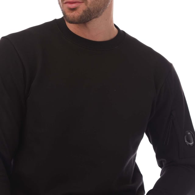 Mens C.P. Company Diagonal Raised Fleece Lens Crewneck Sweatshirt in black.- Ribbed crewneck.- Ribbed cuffs and hem. - Sleeve pocket with lens detail.- Regular fit.- 100% Cotton.- Ref: 18CMSS023A999