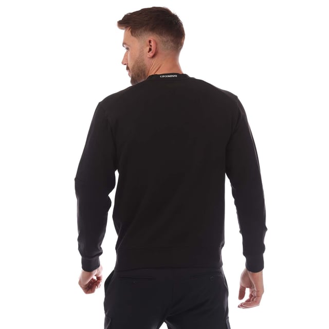 Mens C.P. Company Diagonal Raised Fleece Lens Crewneck Sweatshirt in black.- Ribbed crewneck.- Ribbed cuffs and hem. - Sleeve pocket with lens detail.- Regular fit.- 100% Cotton.- Ref: 18CMSS023A999
