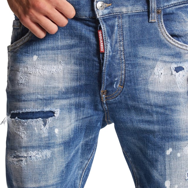 Estilo vaquero súper twinky, mezclilla elástica 93 % algodón, 4 % poliéster, 3 % elastano, bragueta de botones, corte ceñido con pierna cónica, diseño rasgado, detalle de salpicaduras de pintura, mezclilla reforzada desgastada, jeans azules