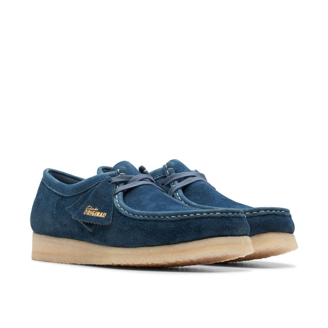 Clean  simple and timeless - our Originals icon is presented in navy and teal to lend a splash of colour to any look. Constructed with an Oasis suede upper from British tannery Charles F Stead  these Wallabees feature a white contrasting stitch on the apron between the vamp and the quarter. Taking you through morning  noon and night  this staple pair will style up every occasion.• CF Stead Oasis navy and teal suede uppers• Includes additional contrasting lace for versatile wear• Natural pebble crepe sole• Clarks Originals heat embossed metallic foil transfer on sock bed• Finished with two Clarks Originals fobs - Clarks Originals and WALLABEES• Moccasin construction