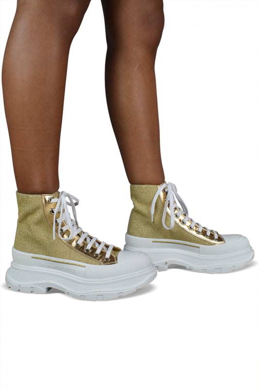 Sneakers altas Alexander McQueen Tread Slick.Lona dorada con efecto brillo.Inserciones de cuero metálico dorado.Puntera redonda con inserción de goma.Logotipo en el mostrador y en la lengüeta.Cierre de cordón plano blanco.Suela de goma blanca sobredimensionada con la firma.Made in Italy.