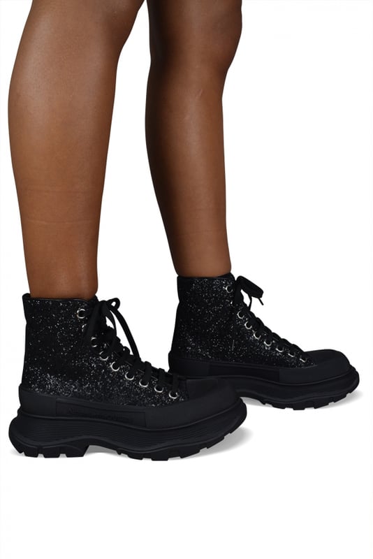 Sneakers altas Alexander McQueen Tread Slick.Lona negra con efecto de brillo.Puntera redonda con inserción de goma.Logotipo en el talón y la lengüeta.Cierre de cordón plano negro.Suela de goma negra sobredimensionada con la firma.Made in Italy.