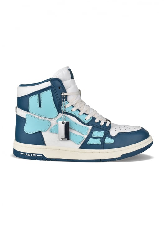 Sneakers altas Skel Top Amiri de piel azul y blanca.Inserciones de cuero azul claro formando un esqueleto.Lengüeta de nailon blanco con logotipo.Placa metálica con el logotipo en la parte delantera.Suela fina de goma azul y blanca con logotipo.Cordones blancos.Puntera redonda.