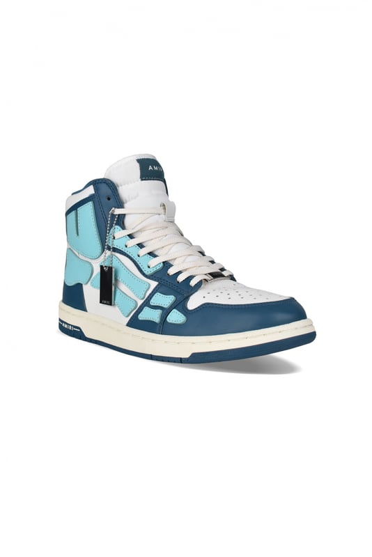 Sneakers altas Skel Top Amiri de piel azul y blanca.Inserciones de cuero azul claro formando un esqueleto.Lengüeta de nailon blanco con logotipo.Placa metálica con el logotipo en la parte delantera.Suela fina de goma azul y blanca con logotipo.Cordones blancos.Puntera redonda.