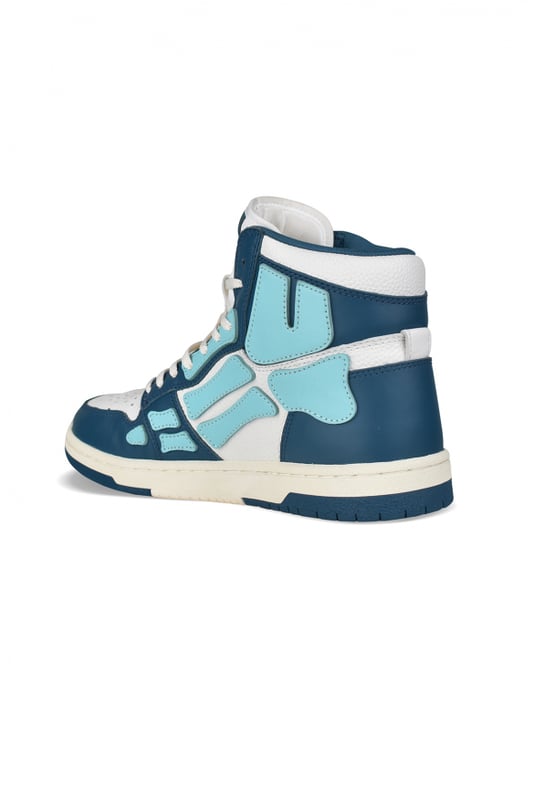 Sneakers altas Skel Top Amiri de piel azul y blanca.Inserciones de cuero azul claro formando un esqueleto.Lengüeta de nailon blanco con logotipo.Placa metálica con el logotipo en la parte delantera.Suela fina de goma azul y blanca con logotipo.Cordones blancos.Puntera redonda.