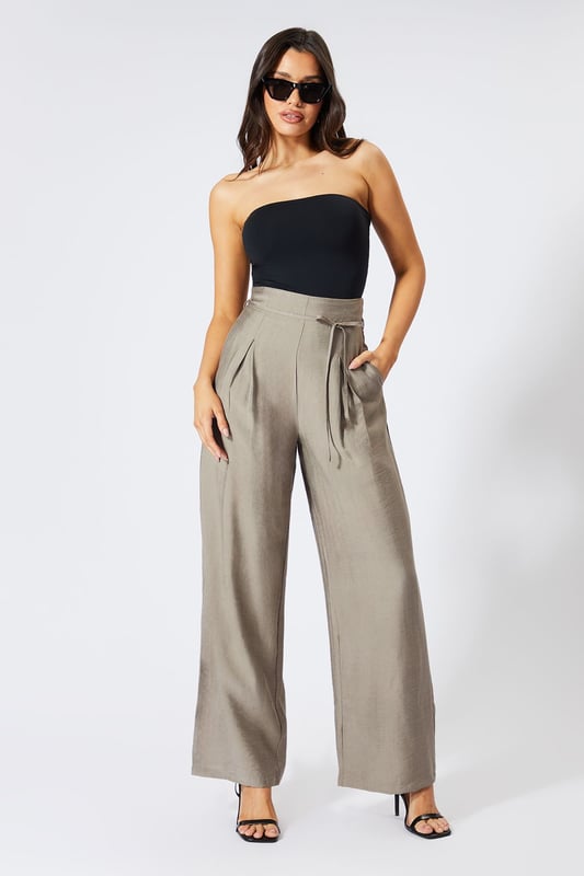 Striking paper bag waist design with self-tie belt for a customisable fit
        Wide leg silhouette creates a dramatic, flowing effect with every step
        High-waisted cut elongates the legs for a flattering profile
        Lightweight linen-look fabric offers breathable comfort for all-day wear
        Side pockets add practical functionality to this fashion-forward piece
    
    These wide leg trousers showcase MissPap's signature blend of comfort and contemporary style. The distinctive paper bag waist creates a gathered effect that cinches in your silhouette, while the flowing wide legs deliver movement and drama. Style them as seen with a one-shoulder bodysuit for casual gatherings, or dress them up with a cropped blouse and strappy heels for evening drinks with the girls. The versatile linen-look fabric transitions effortlessly between seasons-layer with an oversized blazer when temperatures drop or wear alone with a bandeau top during warmer months. Perfect for family brunches, shopping trips with mates, or casual Friday at the office, these trousers offer the ideal balance of relaxed comfort and head-turning style that MissPap devotees adore.