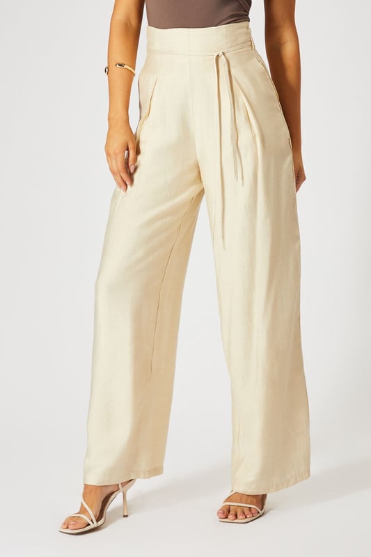 Striking paper bag waist design with self-tie belt for a customisable fit
        Wide leg silhouette creates a dramatic, flowing effect with every step
        High-waisted cut elongates the legs for a flattering profile
        Lightweight linen-look fabric offers breathable comfort for all-day wear
        Side pockets add practical functionality to this fashion-forward piece
    
    These wide leg trousers showcase MissPap's signature blend of comfort and contemporary style. The distinctive paper bag waist creates a gathered effect that cinches in your silhouette, while the flowing wide legs deliver movement and drama. Style them as seen with a one-shoulder bodysuit for casual gatherings, or dress them up with a cropped blouse and strappy heels for evening drinks with the girls. The versatile linen-look fabric transitions effortlessly between seasons-layer with an oversized blazer when temperatures drop or wear alone with a bandeau top during warmer months. Perfect for family brunches, shopping trips with mates, or casual Friday at the office, these trousers offer the ideal balance of relaxed comfort and head-turning style that MissPap devotees adore.