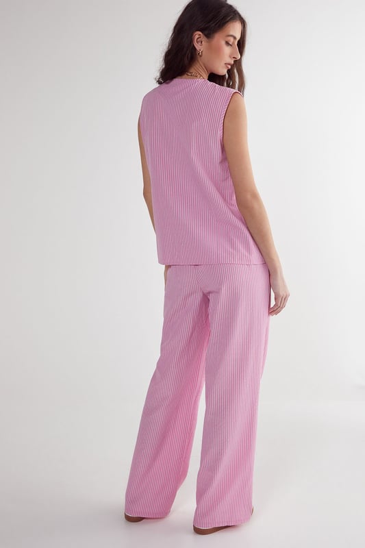 Straight leg design for a classic silhouette
        Vertical stripe pattern adds visual interest
        High-waisted fit for a flattering look
        Side pockets for practicality
        Coordinating sleeveless top with unique front opening
    
    Make a statement with these eye-catching stripe straight leg trousers from NastyGal. The vertical stripe pattern elongates your figure, while the high-waisted design accentuates your curves. Pair with the matching sleeveless top for a coordinated ensemble that's perfect for casual outings or family gatherings. The straight leg cut offers versatility, allowing you to style with trainers for a laid-back look or dress up with heels for a more polished appearance. The side pockets add functionality to this fashionable piece. For a trendy twist, layer with a cropped jacket or oversized blazer. These trousers are a wardrobe essential that can be dressed up or down, making them ideal for various casual occasions throughout the year.