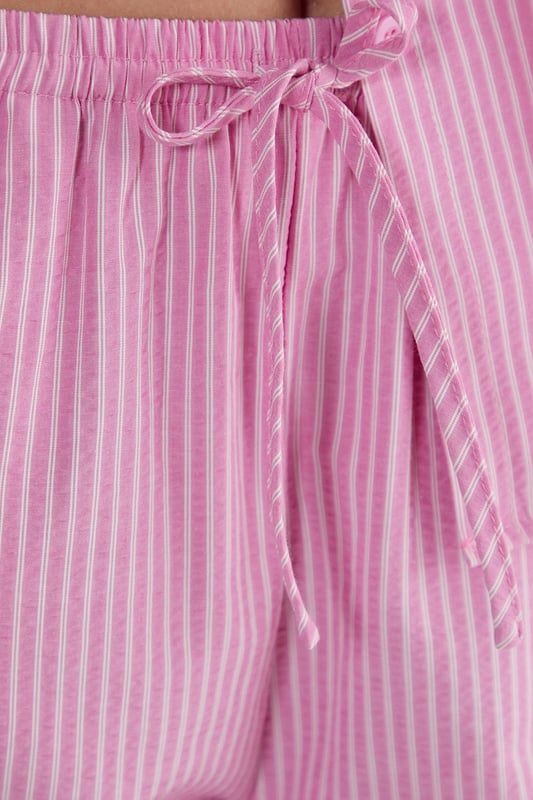 Straight leg design for a classic silhouette
        Vertical stripe pattern adds visual interest
        High-waisted fit for a flattering look
        Side pockets for practicality
        Coordinating sleeveless top with unique front opening
    
    Make a statement with these eye-catching stripe straight leg trousers from NastyGal. The vertical stripe pattern elongates your figure, while the high-waisted design accentuates your curves. Pair with the matching sleeveless top for a coordinated ensemble that's perfect for casual outings or family gatherings. The straight leg cut offers versatility, allowing you to style with trainers for a laid-back look or dress up with heels for a more polished appearance. The side pockets add functionality to this fashionable piece. For a trendy twist, layer with a cropped jacket or oversized blazer. These trousers are a wardrobe essential that can be dressed up or down, making them ideal for various casual occasions throughout the year.