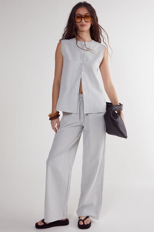 Straight leg design for a classic silhouette
        Vertical stripe pattern adds visual interest
        High-waisted fit for a flattering look
        Side pockets for practicality
        Coordinating sleeveless top with unique front opening
    
    Make a statement with these eye-catching stripe straight leg trousers from NastyGal. The vertical stripe pattern elongates your figure, while the high-waisted design accentuates your curves. Pair with the matching sleeveless top for a coordinated ensemble that's perfect for casual outings or family gatherings. The straight leg cut offers versatility, allowing you to style with trainers for a laid-back look or dress up with heels for a more polished appearance. The side pockets add functionality to this fashionable piece. For a trendy twist, layer with a cropped jacket or oversized blazer. These trousers are a wardrobe essential that can be dressed up or down, making them ideal for various casual occasions throughout the year.