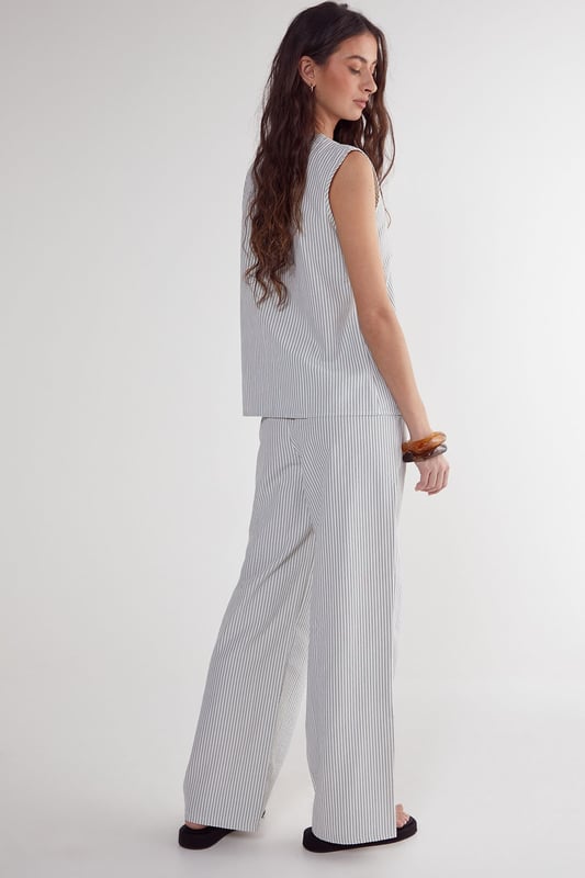 Straight leg design for a classic silhouette
        Vertical stripe pattern adds visual interest
        High-waisted fit for a flattering look
        Side pockets for practicality
        Coordinating sleeveless top with unique front opening
    
    Make a statement with these eye-catching stripe straight leg trousers from NastyGal. The vertical stripe pattern elongates your figure, while the high-waisted design accentuates your curves. Pair with the matching sleeveless top for a coordinated ensemble that's perfect for casual outings or family gatherings. The straight leg cut offers versatility, allowing you to style with trainers for a laid-back look or dress up with heels for a more polished appearance. The side pockets add functionality to this fashionable piece. For a trendy twist, layer with a cropped jacket or oversized blazer. These trousers are a wardrobe essential that can be dressed up or down, making them ideal for various casual occasions throughout the year.