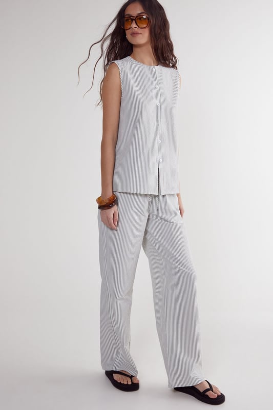 Straight leg design for a classic silhouette
        Vertical stripe pattern adds visual interest
        High-waisted fit for a flattering look
        Side pockets for practicality
        Coordinating sleeveless top with unique front opening
    
    Make a statement with these eye-catching stripe straight leg trousers from NastyGal. The vertical stripe pattern elongates your figure, while the high-waisted design accentuates your curves. Pair with the matching sleeveless top for a coordinated ensemble that's perfect for casual outings or family gatherings. The straight leg cut offers versatility, allowing you to style with trainers for a laid-back look or dress up with heels for a more polished appearance. The side pockets add functionality to this fashionable piece. For a trendy twist, layer with a cropped jacket or oversized blazer. These trousers are a wardrobe essential that can be dressed up or down, making them ideal for various casual occasions throughout the year.