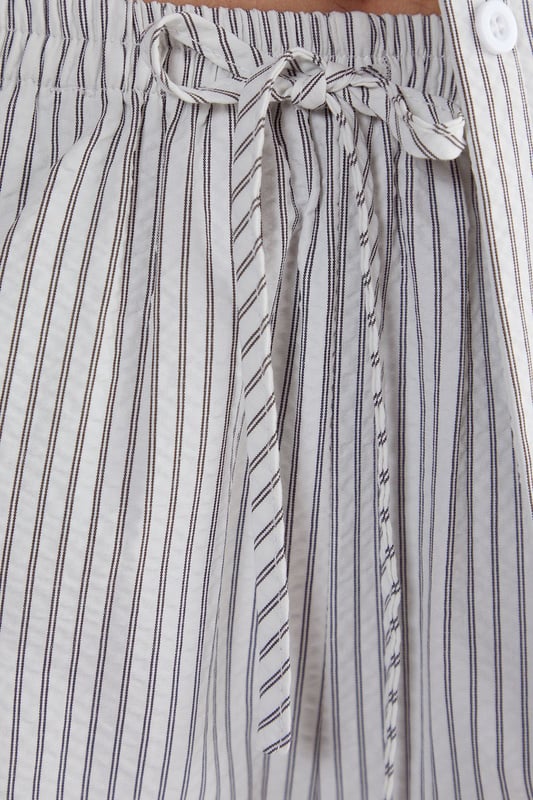 Straight leg design for a classic silhouette
        Vertical stripe pattern adds visual interest
        High-waisted fit for a flattering look
        Side pockets for practicality
        Coordinating sleeveless top with unique front opening
    
    Make a statement with these eye-catching stripe straight leg trousers from NastyGal. The vertical stripe pattern elongates your figure, while the high-waisted design accentuates your curves. Pair with the matching sleeveless top for a coordinated ensemble that's perfect for casual outings or family gatherings. The straight leg cut offers versatility, allowing you to style with trainers for a laid-back look or dress up with heels for a more polished appearance. The side pockets add functionality to this fashionable piece. For a trendy twist, layer with a cropped jacket or oversized blazer. These trousers are a wardrobe essential that can be dressed up or down, making them ideal for various casual occasions throughout the year.