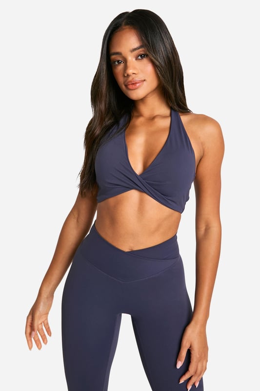 Stylish twist-front design for a unique look
        Halter neck style with racerback for enhanced support
        Soft, stretchy fabric for maximum comfort
        Medium support suitable for various activities
        Coordinating high-waisted leggings available for a complete set
    
    Elevate your workout wardrobe with this Dsgn Studio sports bra, perfect for the fashion-forward fitness enthusiast. The eye-catching twist-front detail adds a touch of style to your gym look, while the halter neck and racerback design provide ample support for medium-impact activities. Pair it with the matching high-waisted leggings for a coordinated ensemble that transitions seamlessly from your workout to casual outings. Layer with a loose-fitting cardigan or hoodie for a trendy athleisure look that's ideal for running errands or meeting friends for a casual coffee. The versatile design makes this sports bra a must-have for yoga sessions, gym workouts, or even as a stylish crop top for summer festivals. With its blend of fashion and function, this Boohoo piece is sure to become a staple in your active and leisure wear collection.