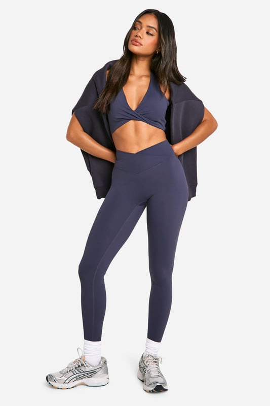 Stylish twist-front design for a unique look
        Halter neck style with racerback for enhanced support
        Soft, stretchy fabric for maximum comfort
        Medium support suitable for various activities
        Coordinating high-waisted leggings available for a complete set
    
    Elevate your workout wardrobe with this Dsgn Studio sports bra, perfect for the fashion-forward fitness enthusiast. The eye-catching twist-front detail adds a touch of style to your gym look, while the halter neck and racerback design provide ample support for medium-impact activities. Pair it with the matching high-waisted leggings for a coordinated ensemble that transitions seamlessly from your workout to casual outings. Layer with a loose-fitting cardigan or hoodie for a trendy athleisure look that's ideal for running errands or meeting friends for a casual coffee. The versatile design makes this sports bra a must-have for yoga sessions, gym workouts, or even as a stylish crop top for summer festivals. With its blend of fashion and function, this Boohoo piece is sure to become a staple in your active and leisure wear collection.