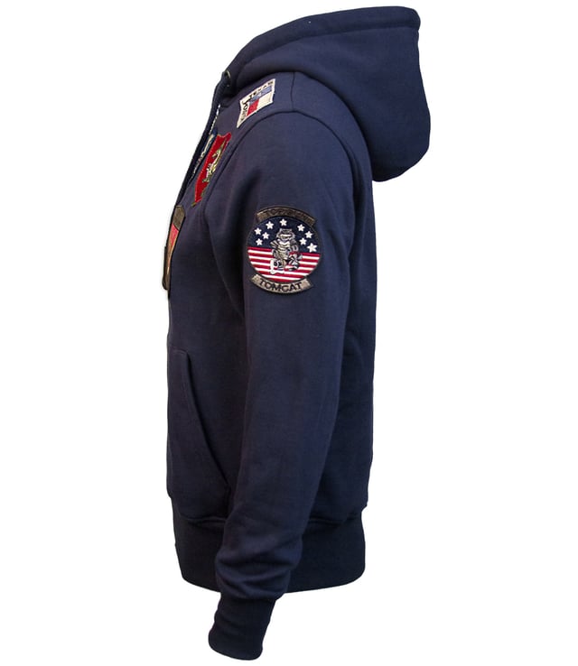 Top Gun Sweatjacke TG20191057 Der einzigartige Top Gun Stil spiegelt sich in dieser hippen Jacke wieder. Sie ist weich gefüttert und besitzt die typische Patches auf der Jacke - sie lässt sich an Lässigkeit kaum überbieten. Der elastische Strick am Ärmelabschluss, Bund und am Kragen sorgt für eine ideale Passform. Zwei seitliche Taschen zum Einschieben bieten genügend Stauraum. Diese Jacke ist der absoluter Hingucker für die etwas kältere Jahreszeit. Mit geraden Reißverschluss und einer Kapuze mit Kordelzug.