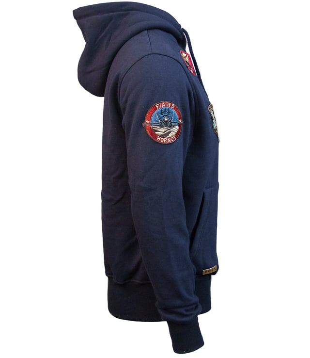 Top Gun Sweatjacke TG20191057 Der einzigartige Top Gun Stil spiegelt sich in dieser hippen Jacke wieder. Sie ist weich gefüttert und besitzt die typische Patches auf der Jacke - sie lässt sich an Lässigkeit kaum überbieten. Der elastische Strick am Ärmelabschluss, Bund und am Kragen sorgt für eine ideale Passform. Zwei seitliche Taschen zum Einschieben bieten genügend Stauraum. Diese Jacke ist der absoluter Hingucker für die etwas kältere Jahreszeit. Mit geraden Reißverschluss und einer Kapuze mit Kordelzug.