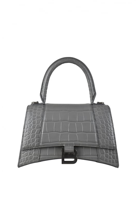 Bolso de mano Balenciaga Hourglass gris.Piel de becerro grabada en cocodrilo.Placa plateada con el logotipo de la firma B.Detalles metálicos plateados.Solapa en la parte superior.Asa redondeada.Compartimento principal y bolsillos interiores con cremallera.Bandolera extraíble y ajustable.Dimensiones: 23 x 14 x 10 cm.Made in Italy.