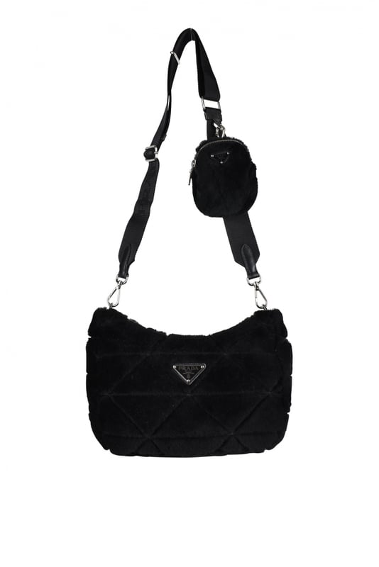 Bolso Prada Re-Nylon en shearling negro.Modelo acolchado con motivo triangular.Logotipo metálico triangular en la parte delantera.Bandolera ajustable de lona con logotipo, 85 cm de largo.Bolsillo extraíble con cremallera de Re-Nylon.Acabado metálico plateado.Cierre principal con cremallera.Dimensiones: 24 x 20,5 x 7 cm.
