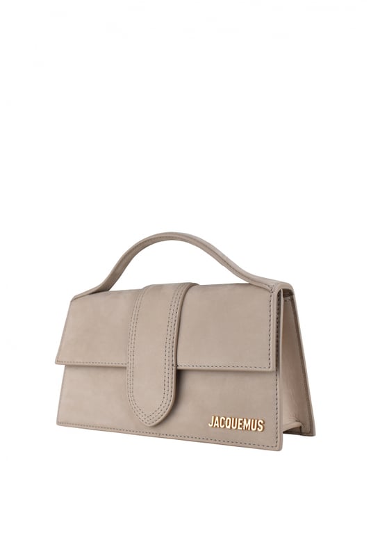 Jacquemus Le Grand Bambino Tasche aus hellbeigem Wildleder.Goldenes Jacquemus-Logo auf der Vorderseite.Verschluss mit magnetischer Klappe.Eine aufgesetzte Tasche auf der Rückseite.Kleiner Tragegriff.Abnehmbarer Schulterriemen. Maße: 23,5 x 13 cm.100% Leder.Made in Italy.