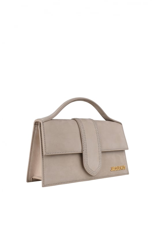 Jacquemus Le Grand Bambino Tasche aus hellbeigem Wildleder.Goldenes Jacquemus-Logo auf der Vorderseite.Verschluss mit magnetischer Klappe.Eine aufgesetzte Tasche auf der Rückseite.Kleiner Tragegriff.Abnehmbarer Schulterriemen. Maße: 23,5 x 13 cm.100% Leder.Made in Italy.