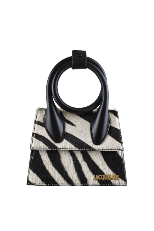 Bolso Jacquemus Le Chiquito Noeud en piel negra y potro.Estampado de cebra en blanco y negro.Asa extensible y ajustable con botón de presión.Logotipo Jacquemus dorado en la parte delantera.Cierre con solapa magnética.Bolsillo interior.Bandolera desmontable.Dimensiones: 18 x 13,5 cm.100% piel.Made in Italy.