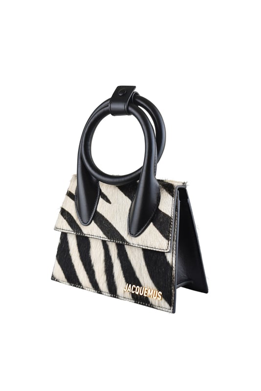 Bolso Jacquemus Le Chiquito Noeud en piel negra y potro.Estampado de cebra en blanco y negro.Asa extensible y ajustable con botón de presión.Logotipo Jacquemus dorado en la parte delantera.Cierre con solapa magnética.Bolsillo interior.Bandolera desmontable.Dimensiones: 18 x 13,5 cm.100% piel.Made in Italy.