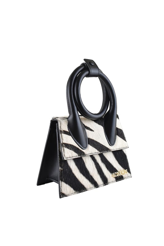 Bolso Jacquemus Le Chiquito Noeud en piel negra y potro.Estampado de cebra en blanco y negro.Asa extensible y ajustable con botón de presión.Logotipo Jacquemus dorado en la parte delantera.Cierre con solapa magnética.Bolsillo interior.Bandolera desmontable.Dimensiones: 18 x 13,5 cm.100% piel.Made in Italy.