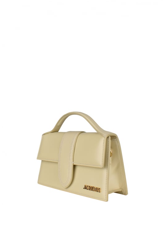 Bolso Jacquemus Le Grand Bambino en piel beige marfil.Logotipo Jacquemus dorado en la parte delantera.Cierre con solapa magnética.Un bolsillo de parche en la parte trasera.Asa pequeña.Bandolera desmontable.  Dimensiones: 23,5 x 13 cm.100% piel.Made in Italy.