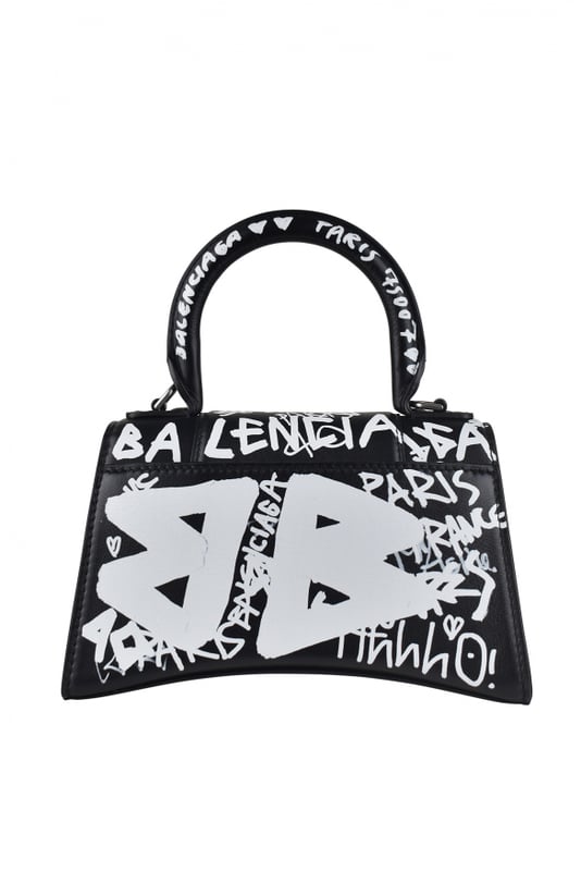Bolso Balenciaga Hourglass XS graphity.Piel efecto negro.Estampado graphity blanco en todo el bolso.Logotipo B  Balenciaga  grabado en metal en la parte delantera.Asa de transporte grande.Bandolera desmontable y ajustable.Solapa delantera con cierre a presión.Tamaño: 19 cm x 13 cm x 8 cm.Tamaño pequeño.Made in Italy.