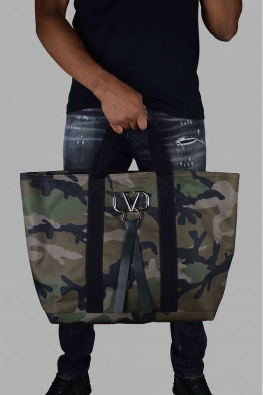 Reistas Valentino camouflage.Metalen V-ring-logo met leren band aan de voorkant.Twee stoffen handvatten.Ritssluiting.Binnenzak met rits.Afmetingen: breedte: 40 cm, hoogte: 37 cm, diepte: 22 cm100% nylon.Gemaakt in Italië.