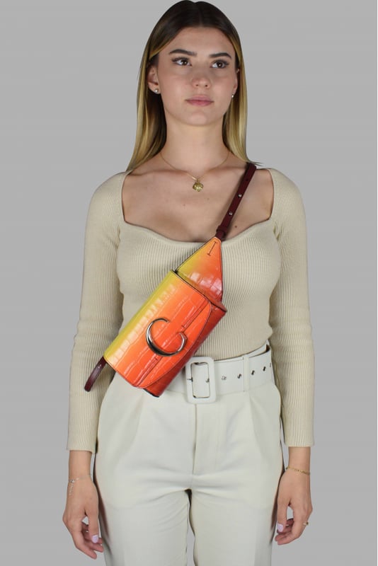 Riñonera Chloé C en piel con relieve de cocodrilo.Gradiente de amarillo y naranja.Solapa con botón magnético.Logotipo C plateado en la parte delantera.Cinturilla ajustable.Dimensiones del cinturón: largo mínimo 52 cm y máximo 62 cm.Dimensiones: ancho 17,5 cm, alto 11 cm, fondo 4 cm.Made in Italy.