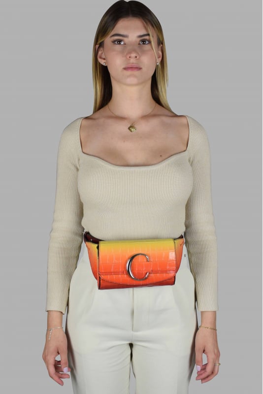 Riñonera Chloé C en piel con relieve de cocodrilo.Gradiente de amarillo y naranja.Solapa con botón magnético.Logotipo C plateado en la parte delantera.Cinturilla ajustable.Dimensiones del cinturón: largo mínimo 52 cm y máximo 62 cm.Dimensiones: ancho 17,5 cm, alto 11 cm, fondo 4 cm.Made in Italy.