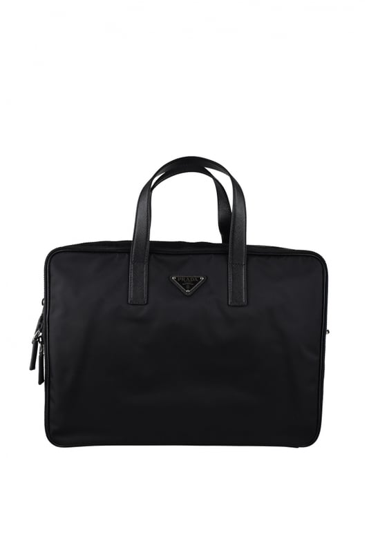 Zwarte Prada re-nylon aktetas.Driehoekig metalen logo op de voorkant.Saffiano lederen handvat.Twee hoofdopeningen met ritssluiting.Verstelbare en afneembare schouderriem.Afmetingen: 28 x 40 x 7 cm.Gemaakt in Italië.